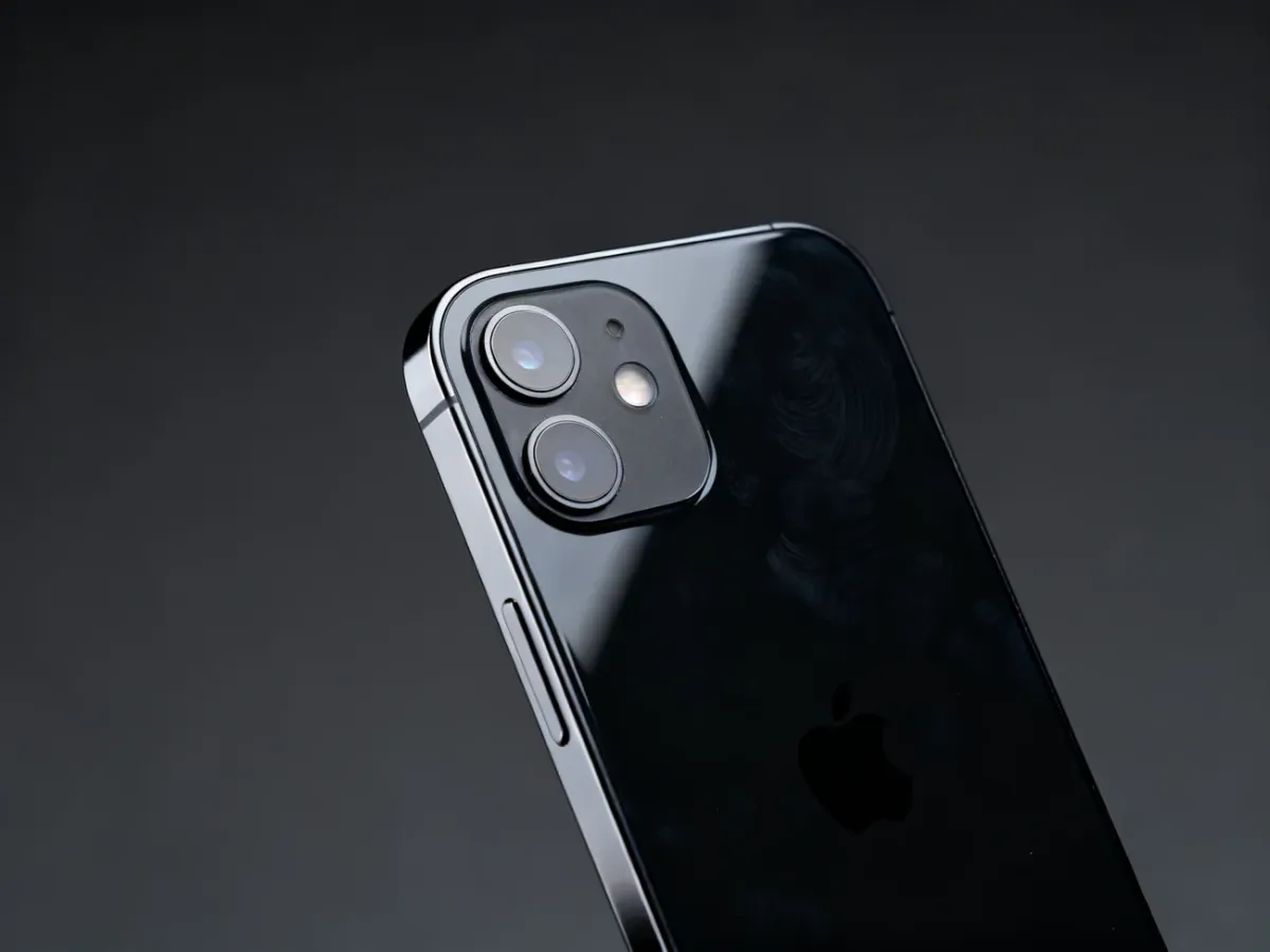 Zbliżenie na czarną, szklaną obudowę iPhone’a 12